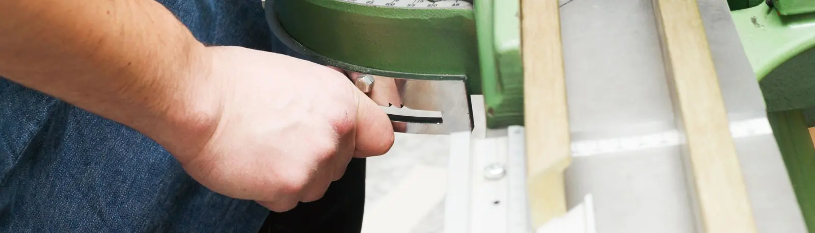 Framer trimming moulding on a mitre guillotine