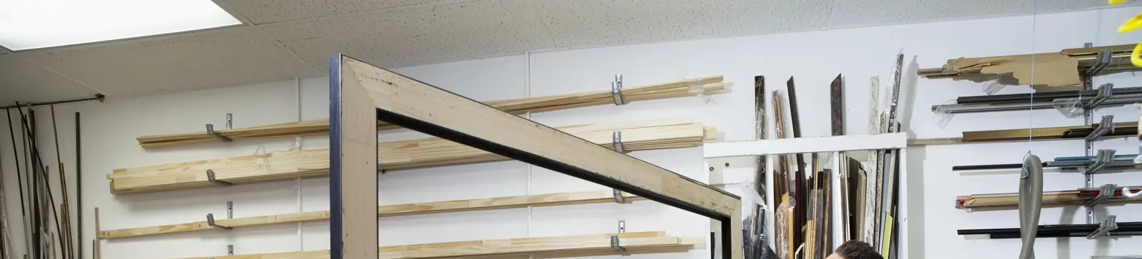 Workshop wall racked with lengths of frame moulding